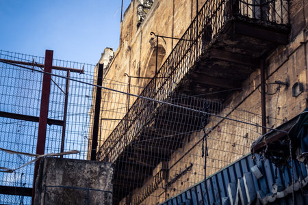 Hebron, West Bank, Palestine, March 28, 2026 Razor wire, metal fencing, and military barriers are prominently installed throughout the ancient streets of Hebron's historic old city. These physical obstructions secure the complex separation zones between tのeditorial素材