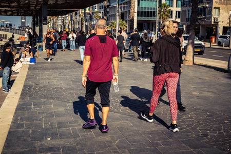 Tel Aviv, Israel, January 3, 2026 Passersby stroll along the Tel Aviv promenade facing the Mediterranean Sea, demonstrating daily resilience despite regional security tensions in the Middle East.のeditorial素材