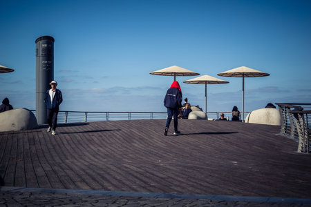 Tel Aviv, Israel, January 3, 2026 Passersby stroll along the Tel Aviv promenade facing the Mediterranean Sea, demonstrating daily resilience despite regional security tensions in the Middle East.のeditorial素材