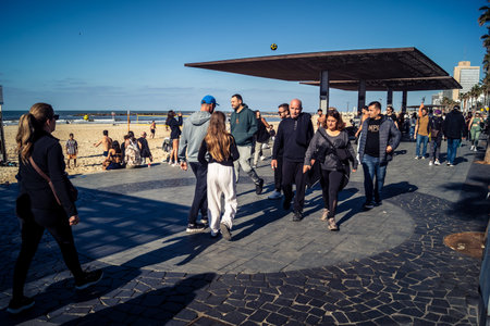 Tel Aviv, Israel, January 3, 2026 Passersby stroll along the Tel Aviv promenade facing the Mediterranean Sea, demonstrating daily resilience despite regional security tensions in the Middle East.のeditorial素材