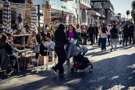 Tel Aviv, Israel, January 3, 2026 Passersby stroll along the Tel Aviv promenade facing the Mediterranean Sea, demonstrating daily resilience despite regional security tensions in the Middle East.のeditorial素材