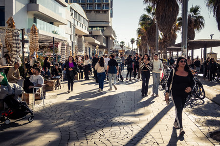 Tel Aviv, Israel, January 3, 2026 Passersby stroll along the Tel Aviv promenade facing the Mediterranean Sea, demonstrating daily resilience despite regional security tensions in the Middle East.のeditorial素材