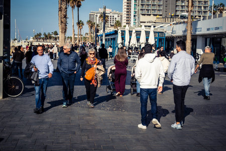 Tel Aviv, Israel, January 3, 2026 Passersby stroll along the Tel Aviv promenade facing the Mediterranean Sea, demonstrating daily resilience despite regional security tensions in the Middle East.のeditorial素材