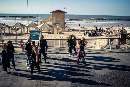 Tel Aviv, Israel, January 3, 2026 Passersby stroll along the Tel Aviv promenade facing the Mediterranean Sea, demonstrating daily resilience despite regional security tensions in the Middle East.のeditorial素材