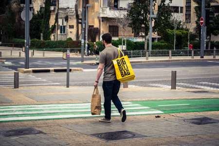 Tel Aviv, Israel, March 7, 2026 People walking through the busy urban streets of Tel Aviv, capturing...