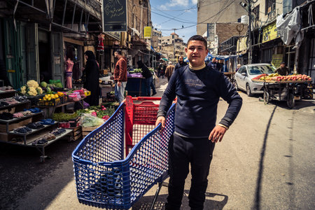 Hebron, West Bank, Palestine, March 31, 2026 Palestinian children are seen pushing metal shopping...
