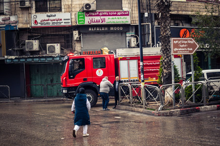 Hebron, West Bank, Palestine, April 01, 2026 A vibrant red Palestinian fire truck navigates through...