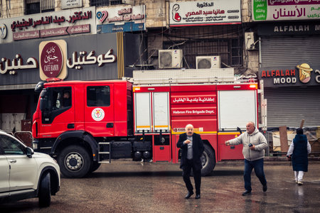 Hebron, West Bank, Palestine, April 01, 2026 A vibrant red Palestinian fire truck navigates through...