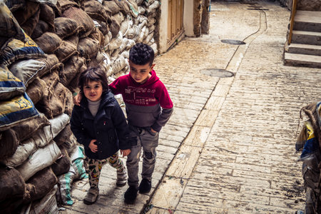 Hebron, West Bank, Palestine, April 01, 2026 Two young Palestinian boys are walking along a narrow,...