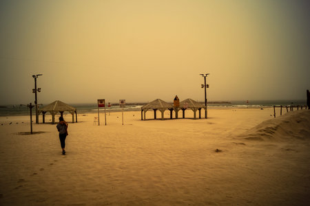 Tel Aviv, Israel, March 14, 2026 Empty playgrounds and beach structures stand abandoned as a thick shroud of desert dust engulfs the Mediterranean coastline, creating a surreal monochromatic landscape and extreme atmospheric conditions during a Sharav eveのeditorial素材