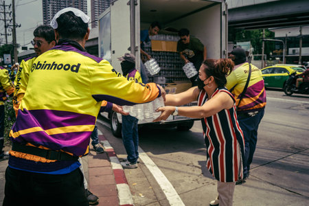 Bangkok, Thailand, March 29, 2025 Volunteers carry water bottles for rescuers at the site of a...