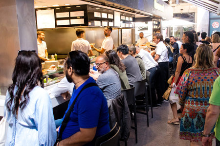 Barcelona, Spain - August 28, 2023 Tourists enjoying at the Boqueria food market in Barcelona, an emblematic city and the capital of Catalogne in Spain.
