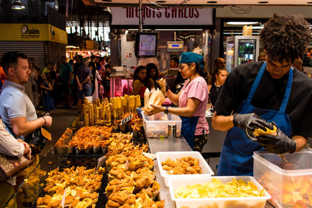 Barcelona, Spain - August 28, 2023 Tourists enjoying at the Boqueria food market in Barcelona, an emblematic city and the capital of Catalogne in Spain.