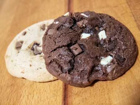 Regular and chocolate homemade cookies. They are on a wooden backgroundの写真素材
