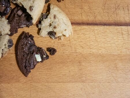 Regular and chocolate homemade cookies. They are on a wooden background