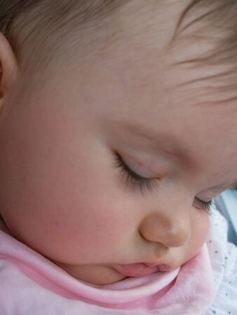 Cute little baby close up. She is peacefully sleeping.の写真素材