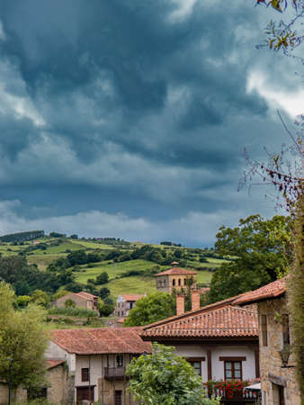 Landscape with a cloudy mountain sky and several village houses in the foreground