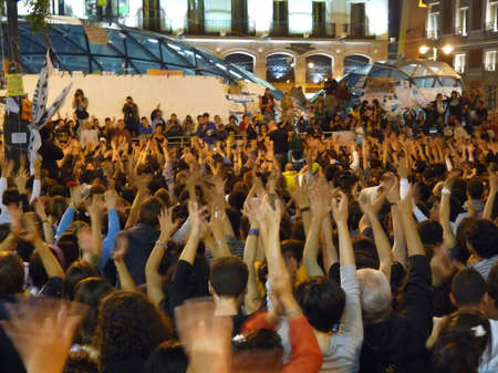 Madrid, Spain; May 27 2011. Protesters raising their hands at a rally during the 15-M Indignados camp at Puerta del Sol in Madrid. Photography taken on May 27 2011 in Madrid, Spainのeditorial素材