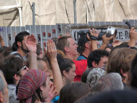 Madrid, Spain; June 11 2011. Cameraman filming 15-M Indignados demonstrators' protests and encampment at Puerta del Sol in Madrid. Photography taken on June 11 2011 in Madrid, Spainのeditorial素材