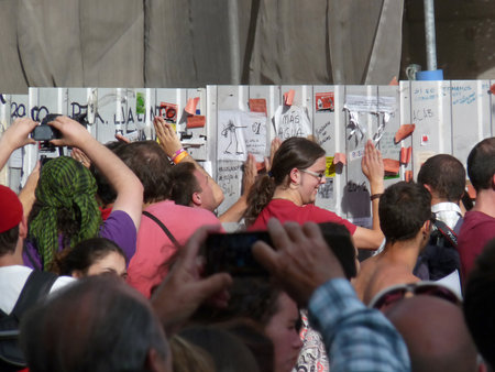 Madrid, Spain; June 11 2011. Young people hitting a construction site barrier in protest. 15-M Outraged protests at Puerta del Sol in Madrid. Photography taken on June 11 2011 in Madrid, Spainのeditorial素材