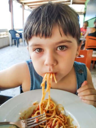 Little girl eating spaghetti in a really untidy mannerの写真素材