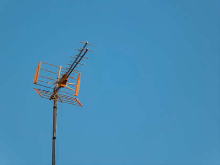 Telecommunication antenna under a clear blue sky on a sunny dayの写真素材