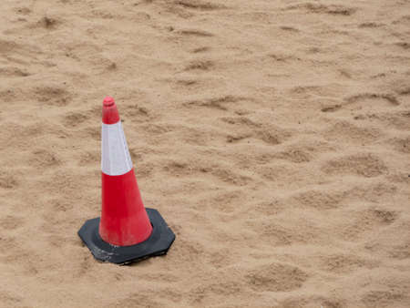 Close-up of warning cone on the sand of a beachの写真素材