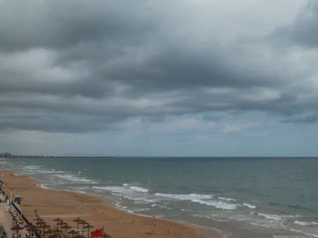 Seascape on a cloudy summer morning with calm sea in Valencia, Spainの写真素材