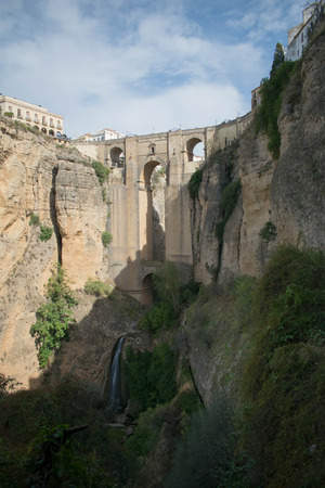 a head on shot of the bridge in Ronda, Spain with as shadow cutting across itの写真素材
