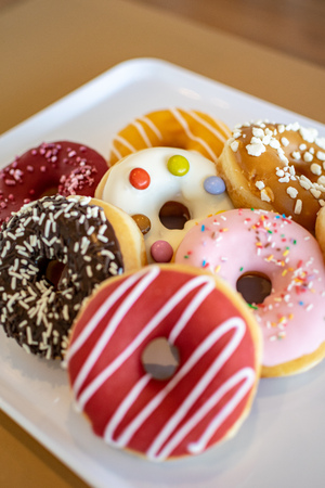 a collection of fruity doughnuts on a trayの写真素材
