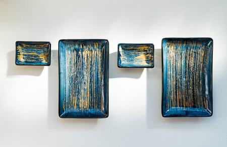 a pair of ceramic sushi plates with matching soy sauce dishes