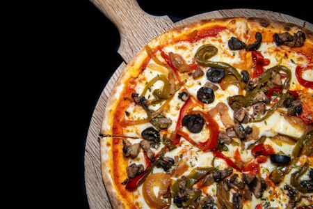 a close up on a freshly baked vegetarian pizza straight out the ovenの写真素材
