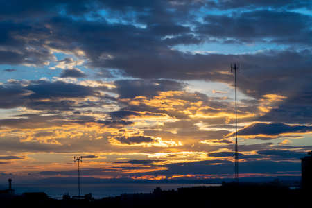a colourful tropical autumn sunset overlooking the Mediterranean sea with a city silhouette