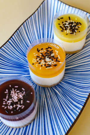 a trio of mini cheesecake desserts in various flavours on a plate close upの写真素材
