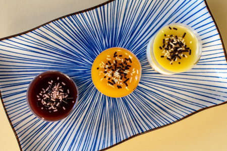a trio of mini cheesecake desserts in various flavours on a plate close up landscape