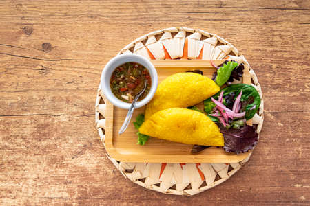 a Colombian empanada filled with pulled pork and served with Pico de Galloの写真素材