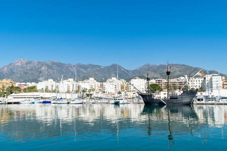 a black pirate style ship docked in the fishing port of Marbella, Spainの写真素材