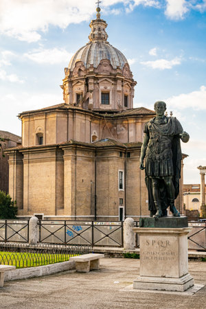 The statue of Julius Caesar in bronze at the place of his assassination in front of the Forum Iulium in Romeの写真素材
