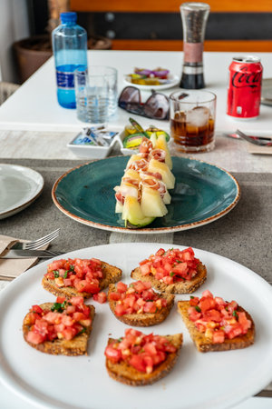 a table of mediterranean food with focus on the white melon served with jamon serrano.