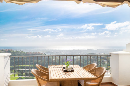 a dining table on a luxury apartment terrace with views overlooking the town of Marbellaの写真素材