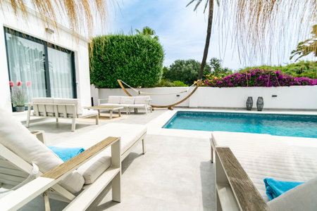 Luxury swimming pool in hotel resort with deck chairs and blue sky