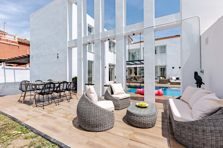 Outdoor patio with wicker chairs and table in a modern house
