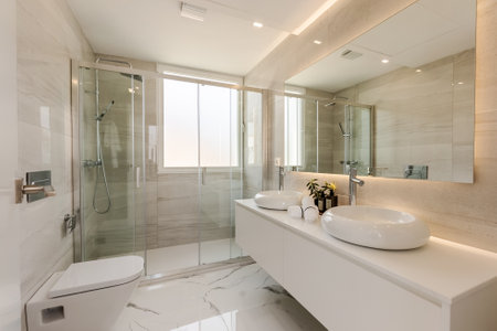 Interior of a modern bathroom with white marble and glass shower. Nobody inside