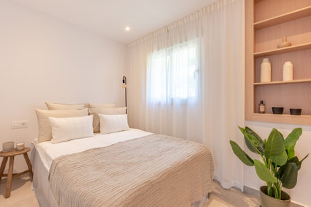 an image of a small guest bedroom with wooden shelving in mediterranean holiday homeの写真素材
