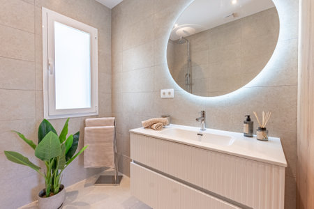 an image of a bathroom with stone wall tiles and illuminated mirror in mediterranean holiday home