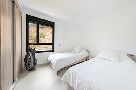 an image of two single beds with a set of golf clubs in mediterranean holiday homeの写真素材