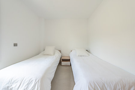 an image of two single beds with white sheets in a mediterranean hotelの写真素材