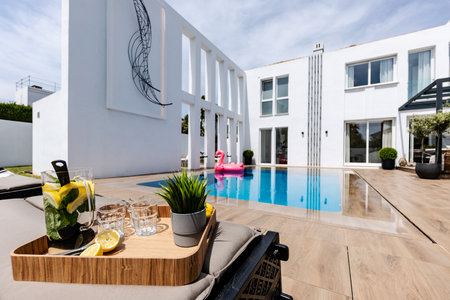 a luxury poolside image of fresh lemonade Infront of an infinity swimming pool in mediterranean...