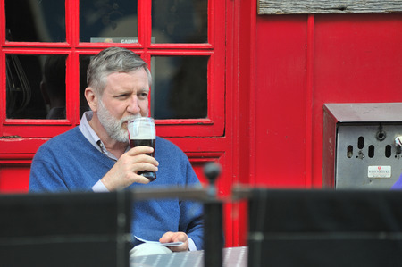 Galway City Center, Ireland June 2017,Man Drinking a Pint of Guiness in a Bar Terraceのeditorial素材