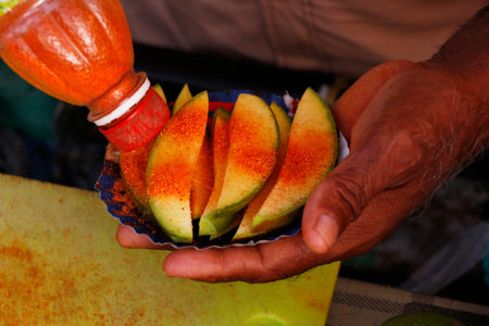 Indian street food in a street stall., Kerala India. Summer special sweet and sour pineapple, mango slice. fruits marinated with salt and chilly powder. Pickledの写真素材